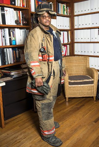 male firefighter standing in front of a bookcase
